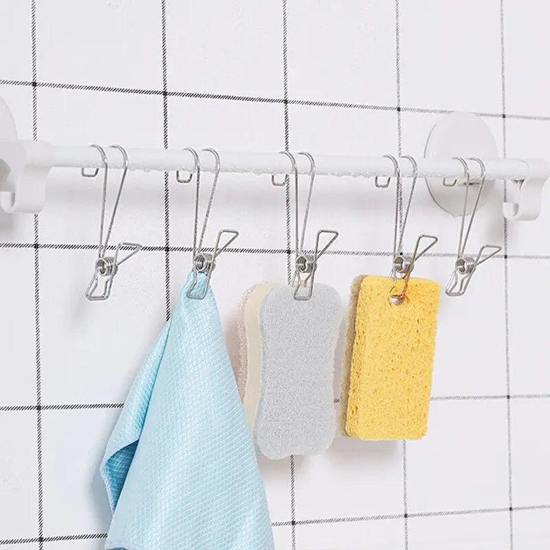 a white coat rack with three hooks and two towels hanging on it