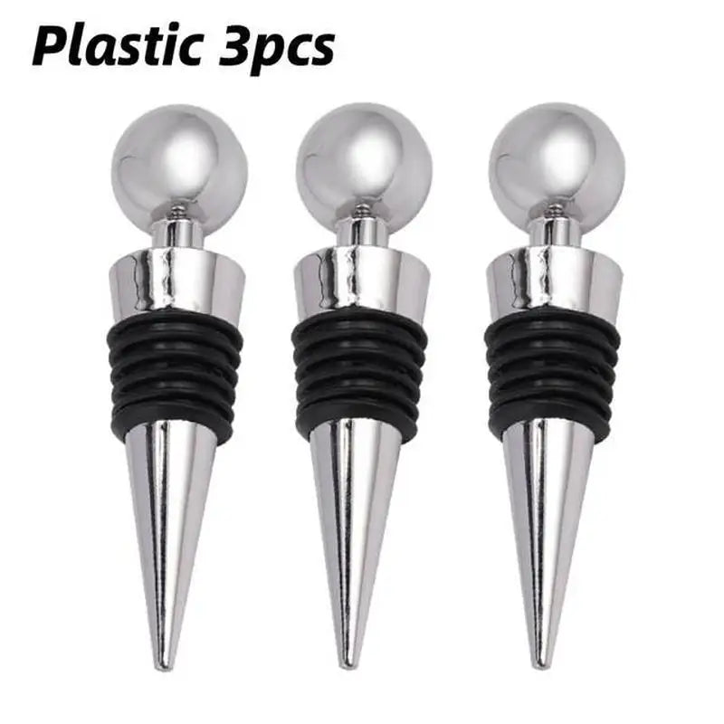 three silver metal wine stoppers with black plastic tops