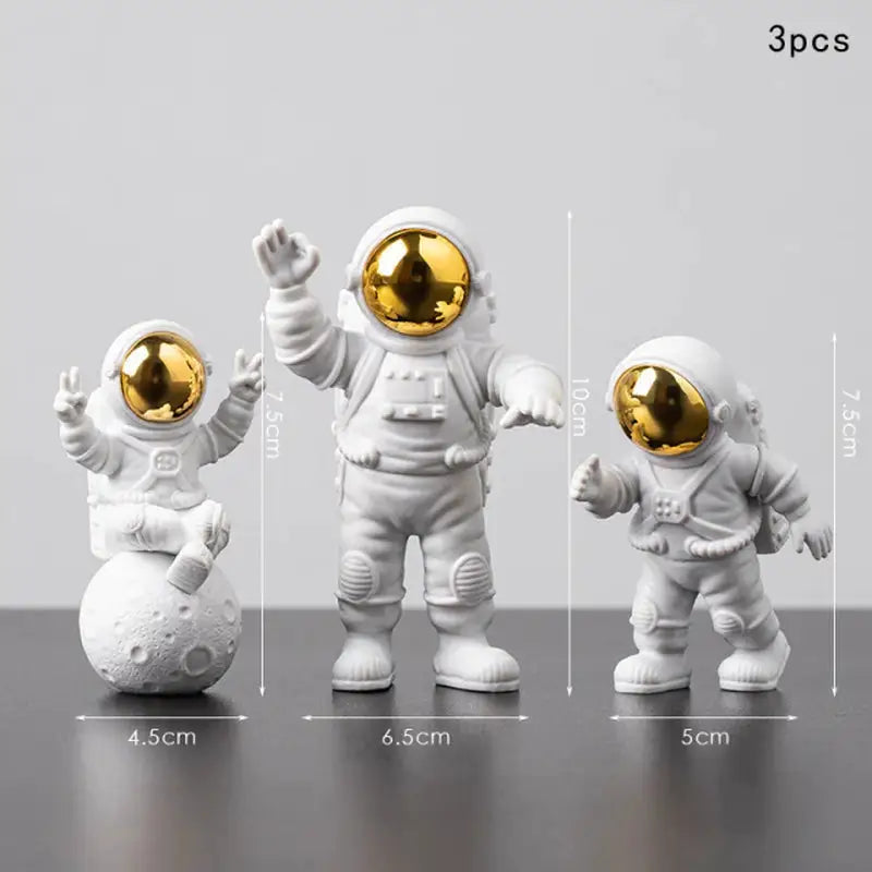 three astronaut figuris with gold and silver