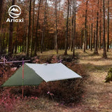 a tent in the woods with a tent attached to it