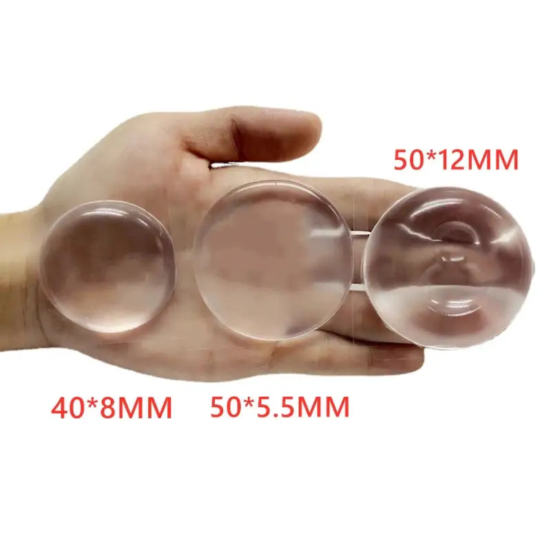 a hand holding three clear glass spheres