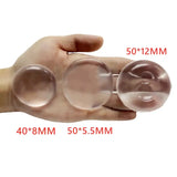 a hand holding three clear glass spheres