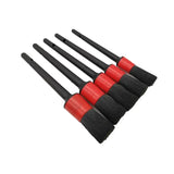 a set of five black and red brushes with red handles