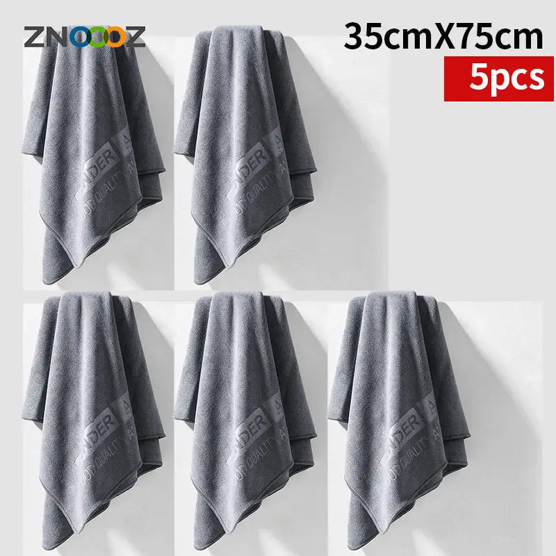 four towels hanging on a wall with a white background