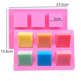 a pink plastic soap tray with four different colored soaps