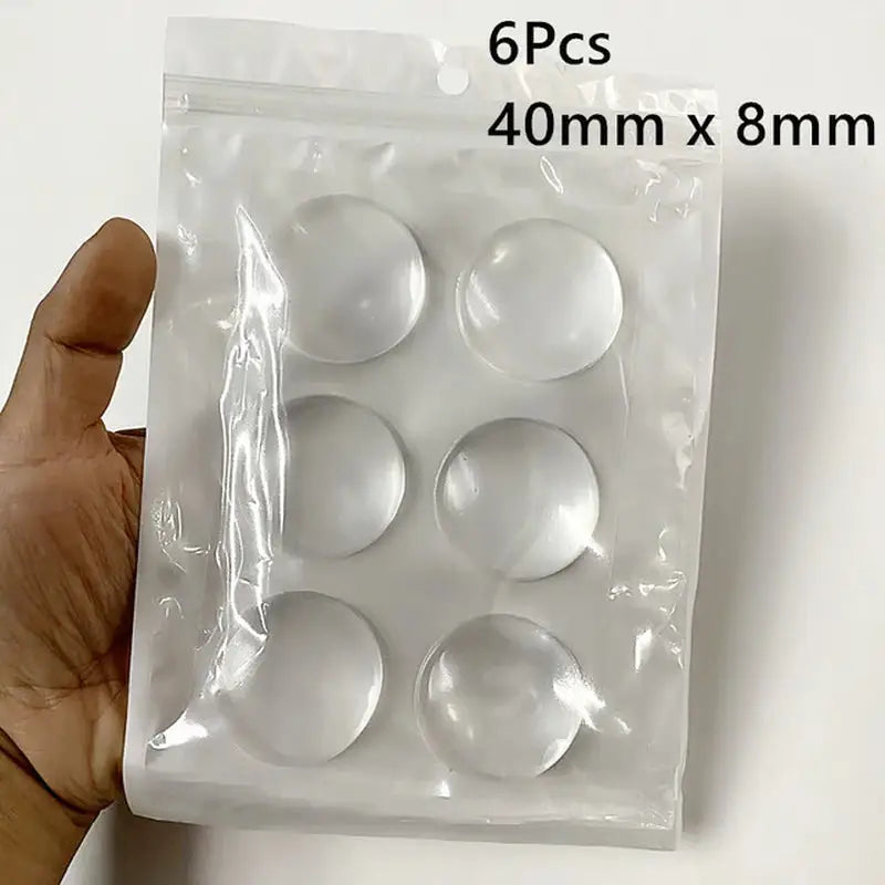 a hand holding a pack of white plastic buttons