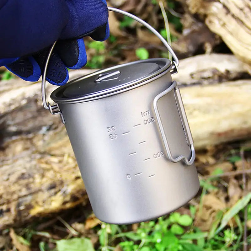 a person holding a metal cup with a handle