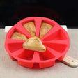 a red plastic cutter with a piece of bread in it