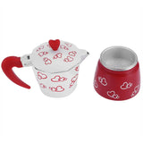 a red and white tea pot with a red handle