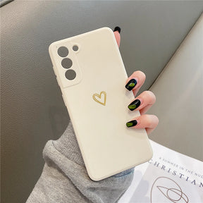 Cream-colored phone case with a gold heart design and three camera cutouts.
