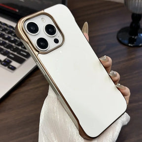 White iPhone 15 Pro Max with a gold-toned protective case.