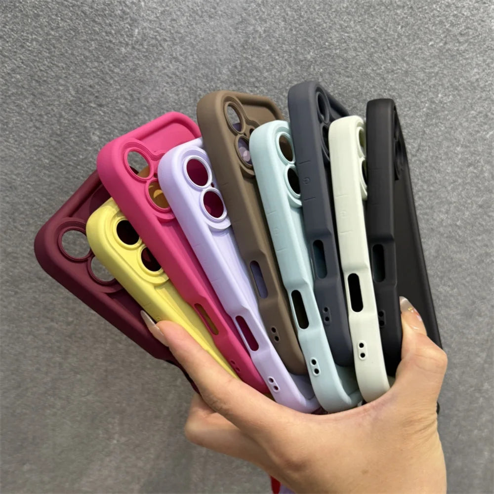 A hand holding a fanned assortment of colorful silicone phone cases.