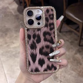 A pink leopard print phone case with a diamond-studded border.