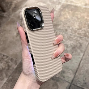A hand holding a beige iPhone case with diagonal ribbed texture and a metallic camera frame.