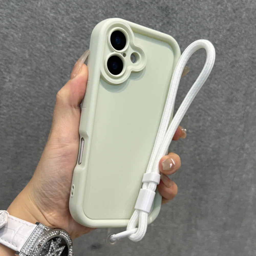 A light green iPhone case with a white wrist strap, featuring a distinctive camera cutout design.