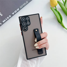 A smartphone in a matte brown case with a black strap holder and prominent camera lenses.