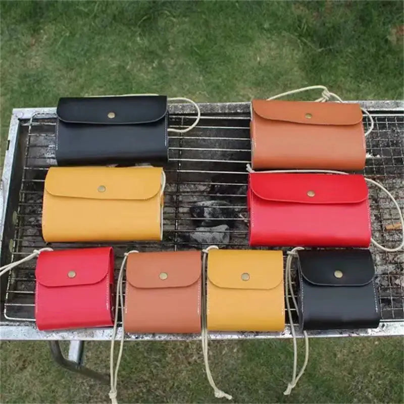 a bunch of different colored leather bags on a grill