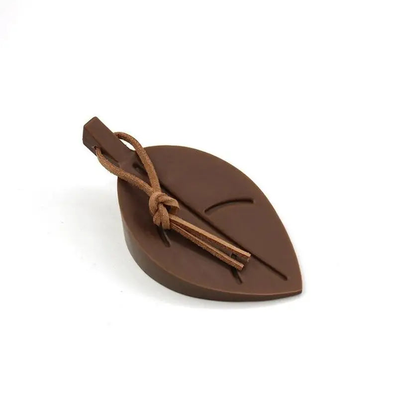 a chocolate leaf shaped pendant with a brown cord