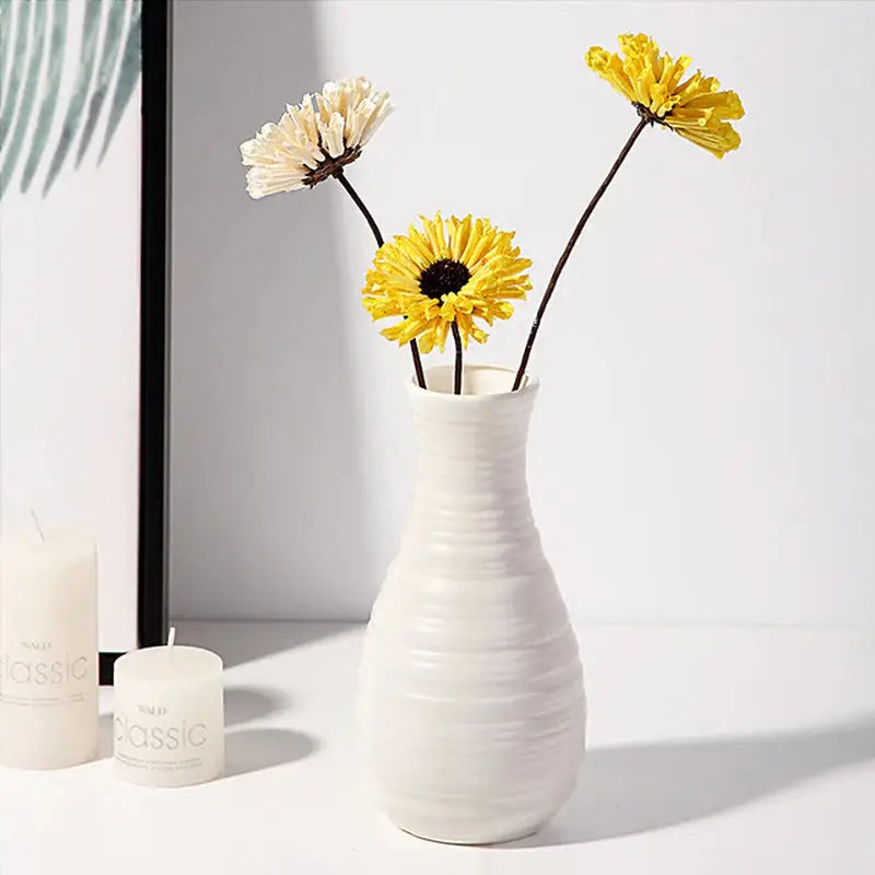 a vase with flowers in it and a candle
