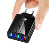 a close up of a person holding a black charger with three usb ports