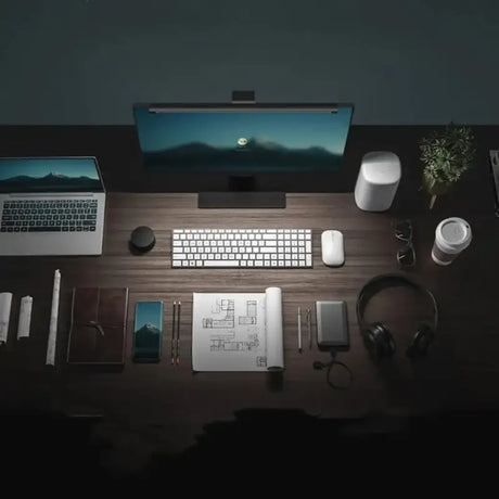 Arafed desk with a laptop, keyboard, mouse, headphones, and other items