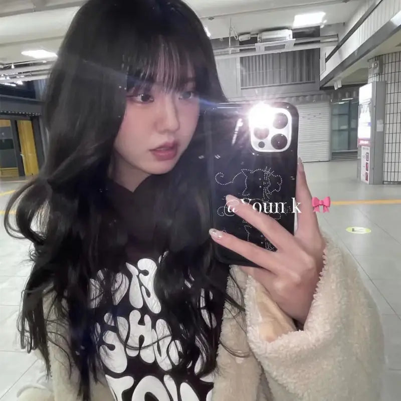 araffe girl with long black hair taking a selfie in a subway