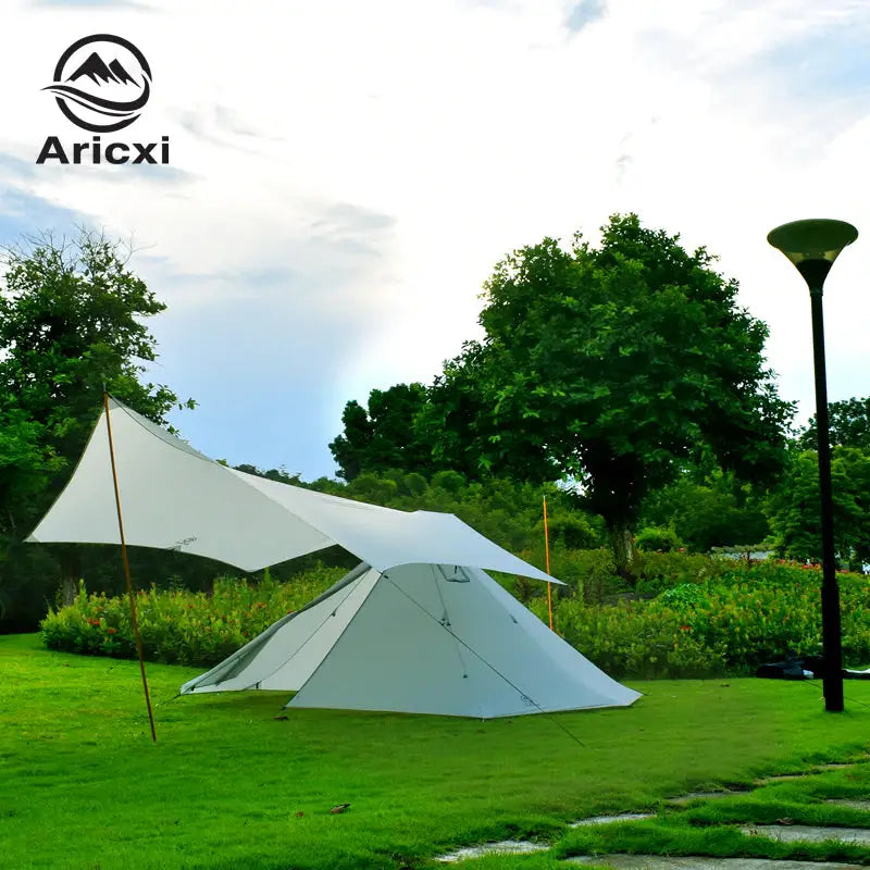 a tent with a white canopy on the grass