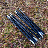 four black and silver pens sitting on top of a field