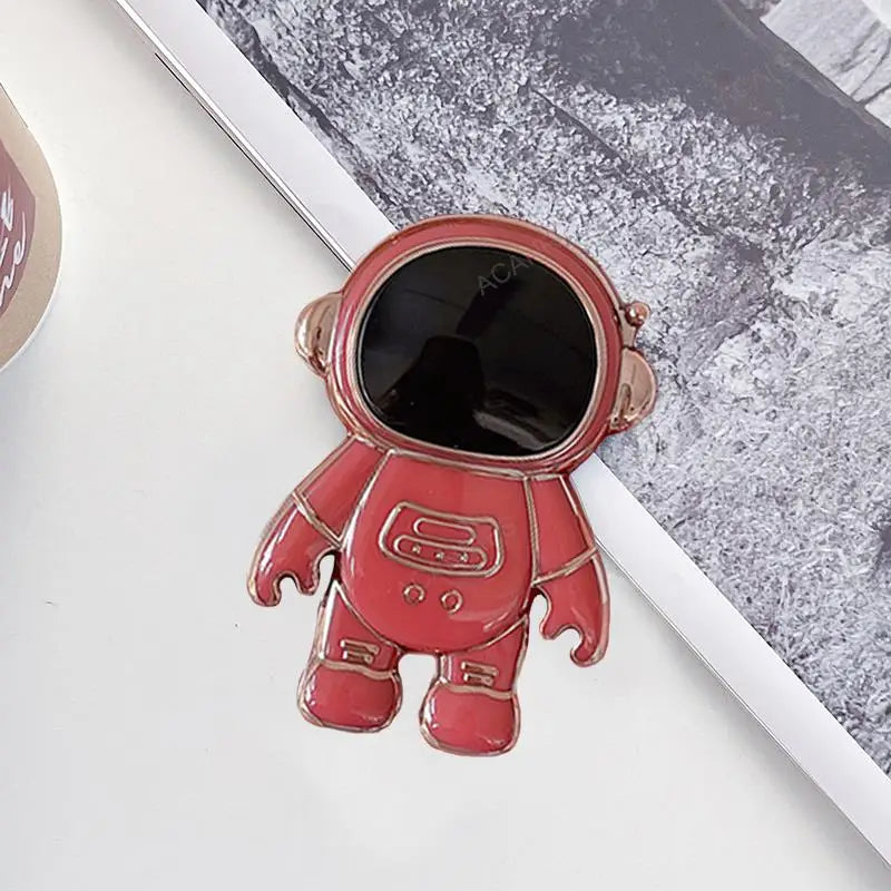 a red astronaut pin with a black hole in the middle