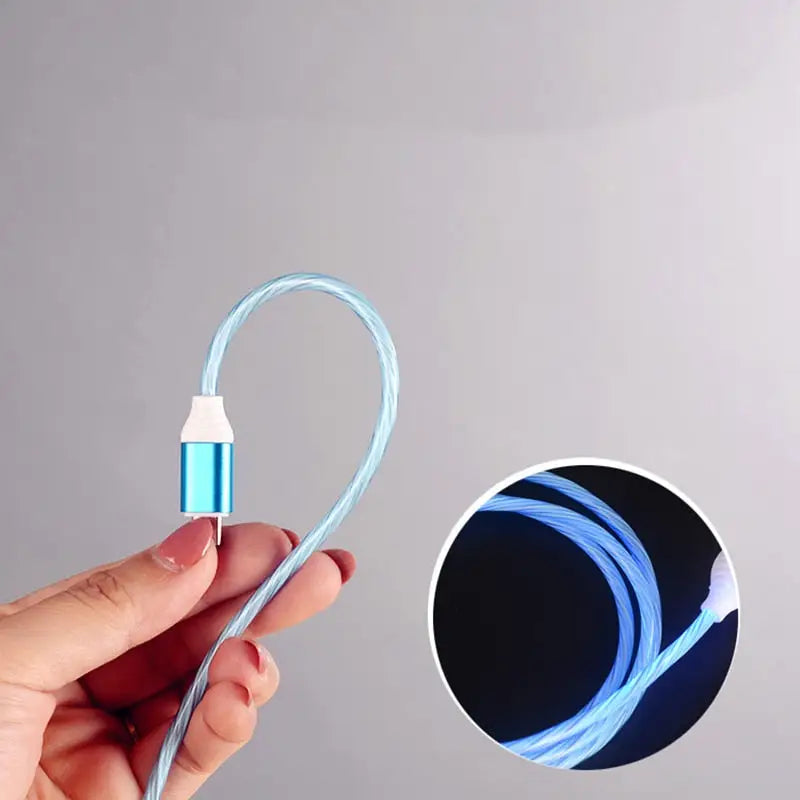 a hand holding a blue light cable