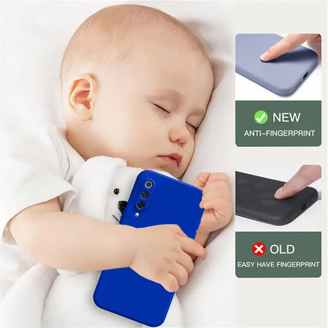 A baby sleeping on a bed with a phone case