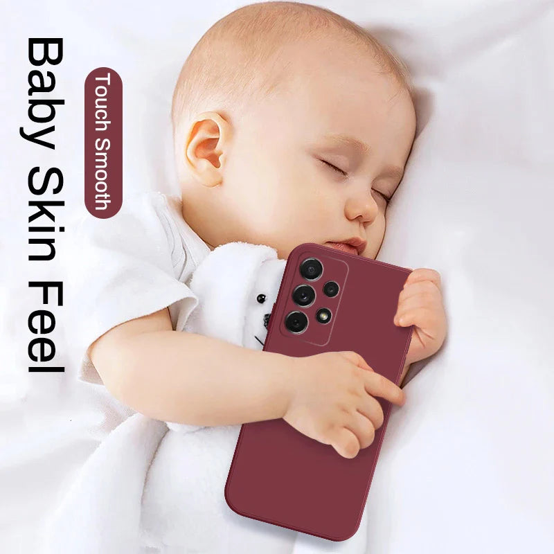 a baby sleeping on a bed with a phone case