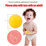 a baby is playing with a yellow ball