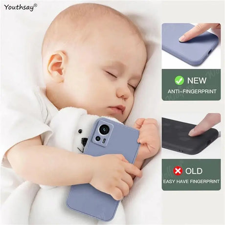 a baby sleeping on a bed with a phone case