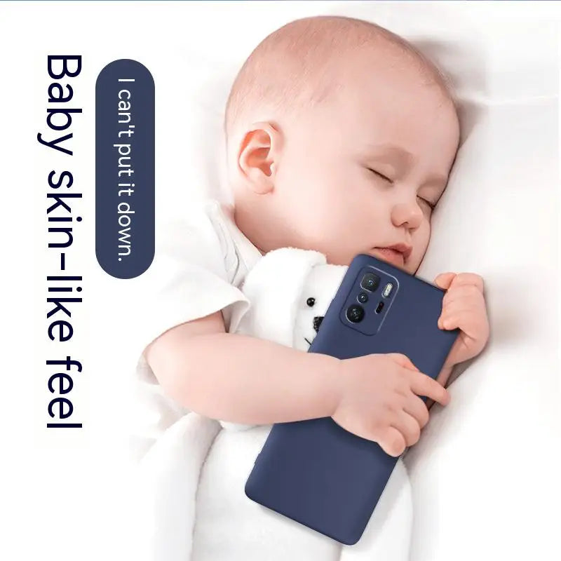 a baby sleeping on a white blanket with a blue phone case