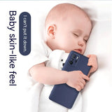 a baby sleeping on a white blanket with a blue phone case