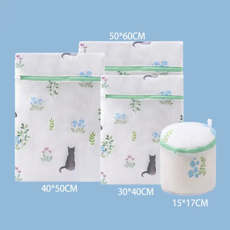 there are three bags with a cat design on them and a cup