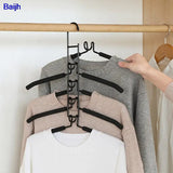 a person is holding a hanger on a clothes rack