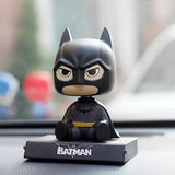 a batman figurin sitting on top of a car