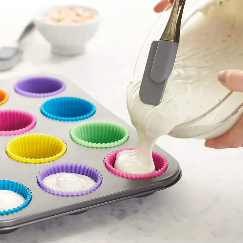 someone is pouring batter into a muffin tin with cupcake liners