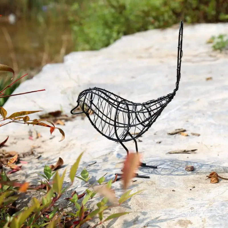 a wire bird sculpture on a rock