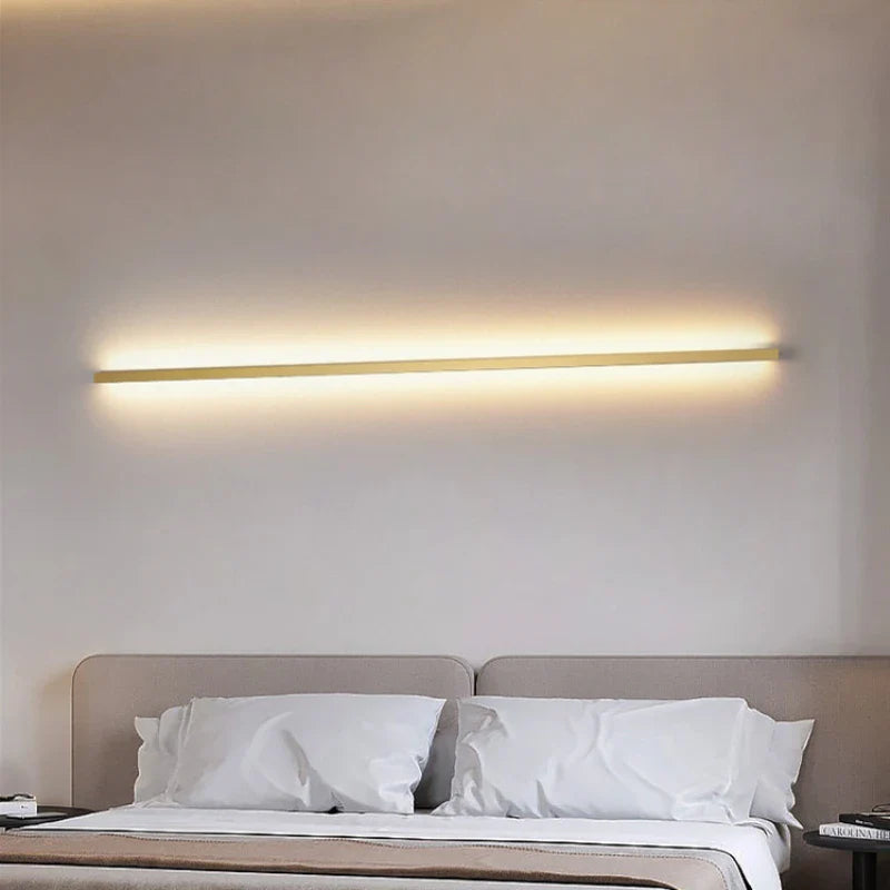 a bed with a white comforter and a wall light