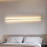 a bed with a white comforter and a wall light