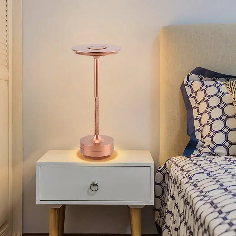 a bedside with a lamp on top of it