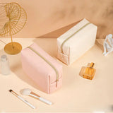 a pink makeup bag with a gold stripe