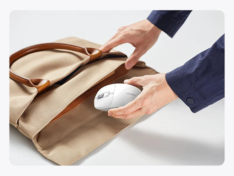 Beige tote bag with hands placing a white electronic device inside.