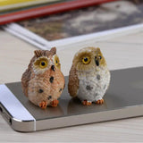 two small birds sitting on top of a phone
