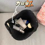 a black bag with a small amount of cosmetics inside