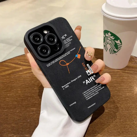 Someone holding a black case with a starbucks logo on it