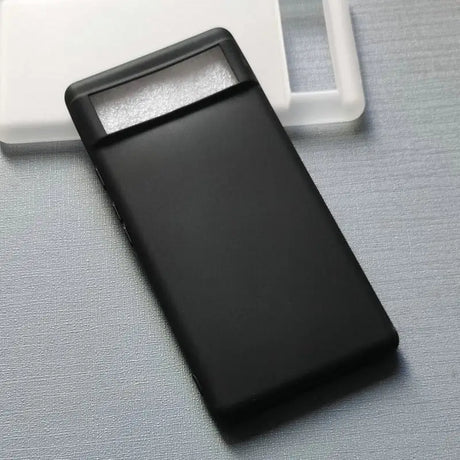 a black cell phone sitting on top of a white surface